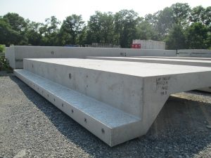 Precast pool wall sections lie to cure in the sun.